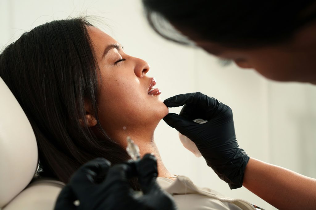Mujer recibiendo un tratamiento de bruxismo con infiltración en el músculo masetero en una consulta de medicina estética en Valladolid